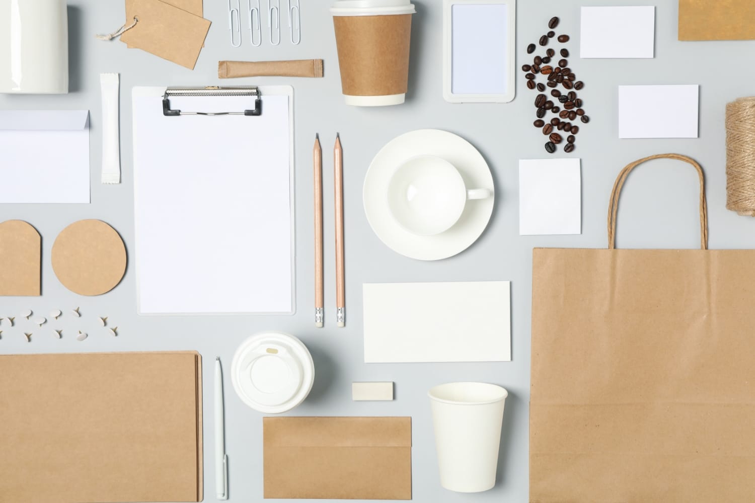 Assorted graphic design elements including stationery, coffee cup, and branding materials, showcasing tools for enhancing brand identity and visual communication.