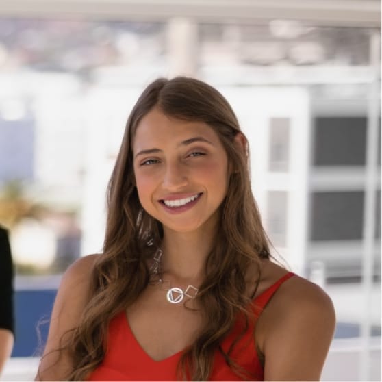 Smiling woman in a red dress, showcasing confidence and positivity, representing client success stories for Brandmode's digital marketing services.