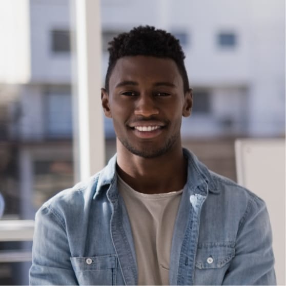Smiling man in a denim jacket, representing client satisfaction and success with Brandmode's digital marketing services.