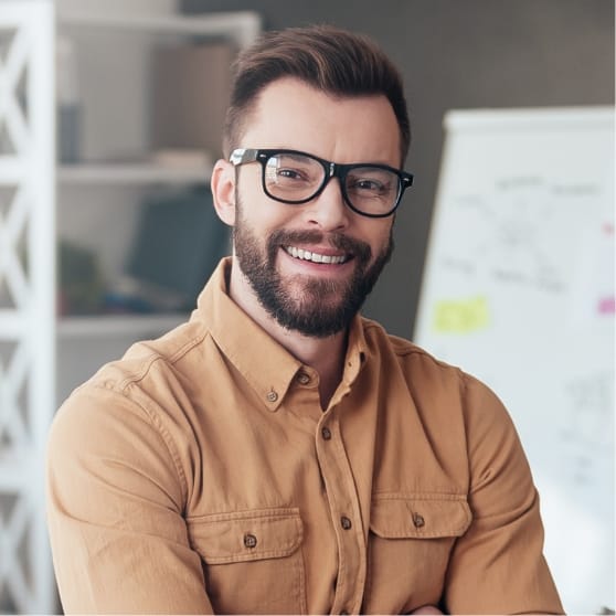 Smiling man with glasses in a professional setting, representing Brandmode's client success and digital marketing expertise.